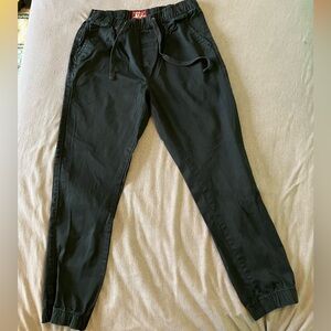 Match Black Drawstring Pants with Red Logo Patch